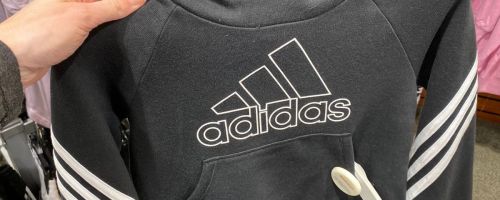 Hand holding an adidas sweatshirt