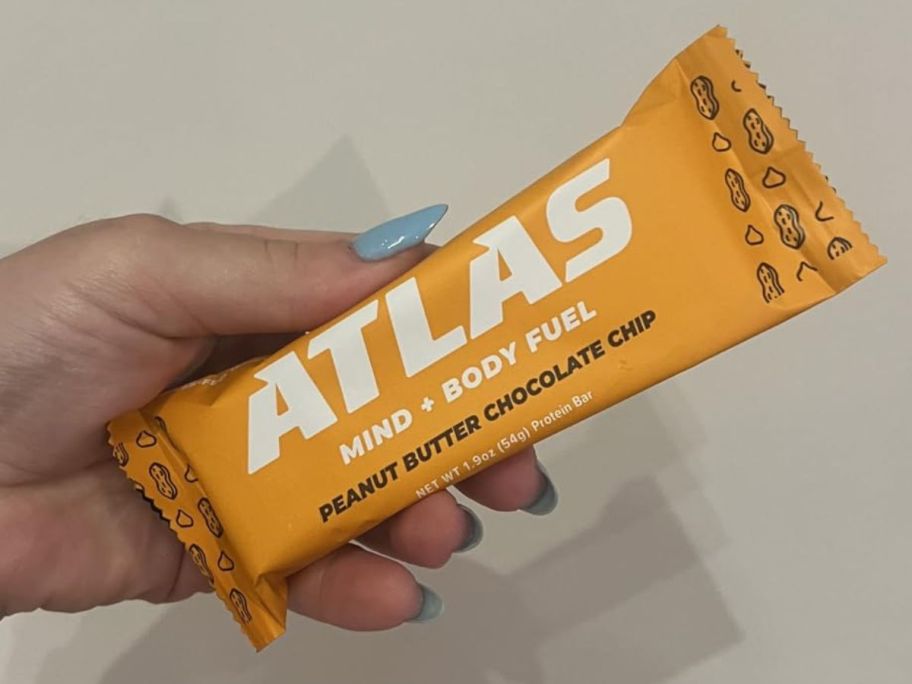 A person holding an Atlas Peanut Butter bar