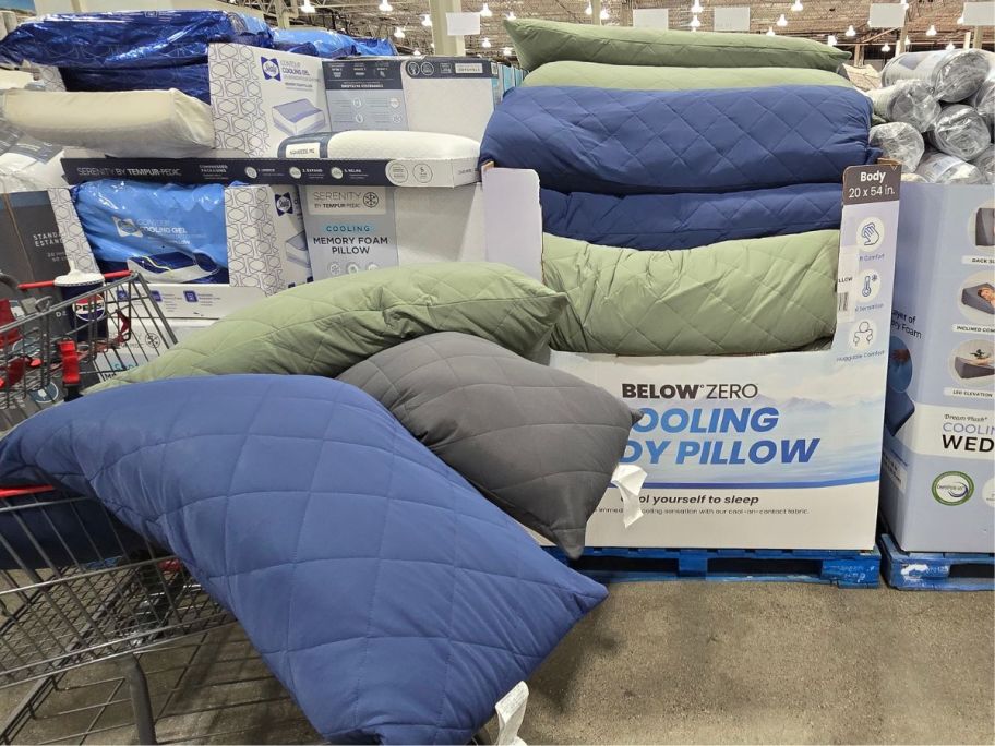 A cart of Below Zero Cooling Body Pillows next to a box display with more pillows at Costco