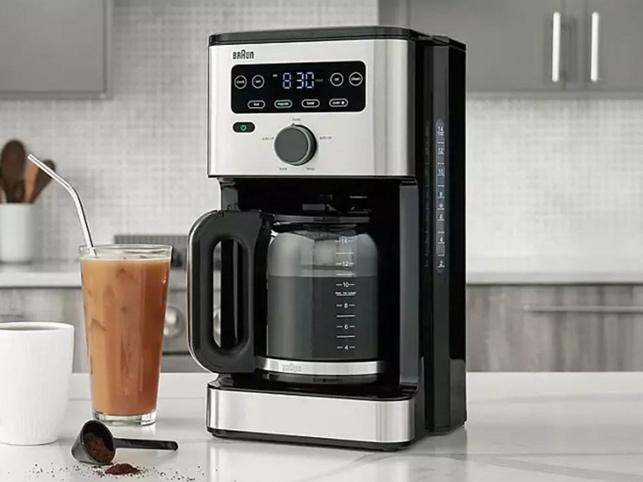 coffee maker on counter top next to iced coffee