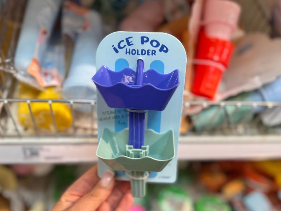 A person holding blue and green ice pop holders