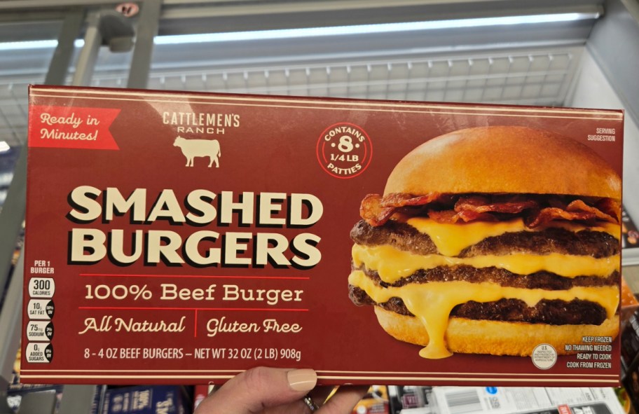 hand holding smash beef burgers box in front of a store freezer