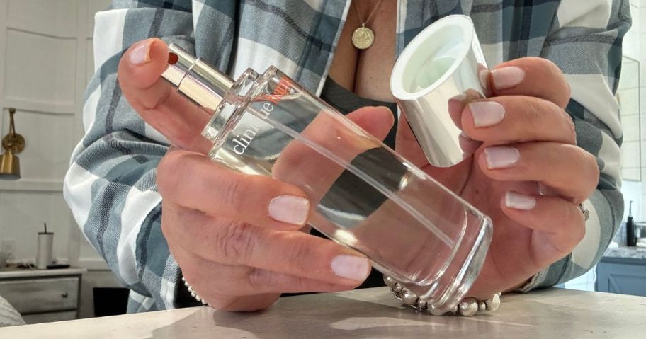 Hand holding a bottle of Clinique Happy Perfume