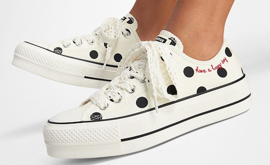 woman wearing a pair of white and black polka dot platform sneakers