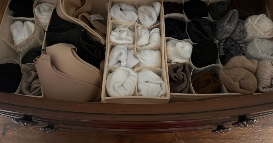An 8-piece drawer organizer set in a drawer with articles of clothign in it 