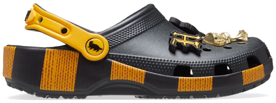 Crocs Adult Harry Potter Hufflepuff Classic Clogs in black and yellow, featuring house-themed charms, striped accents, and pivoting heel strap