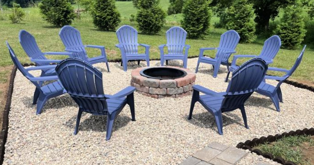 Dark blue plastic Adirondack chairs in circle around stone fire pit