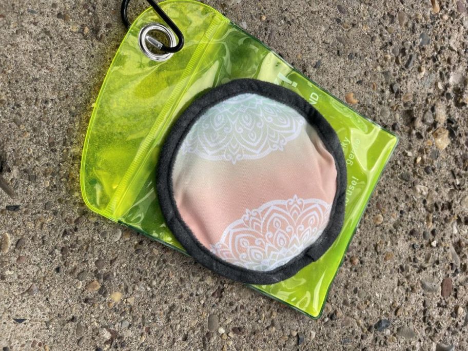 A pastel circular sand removing pad with case