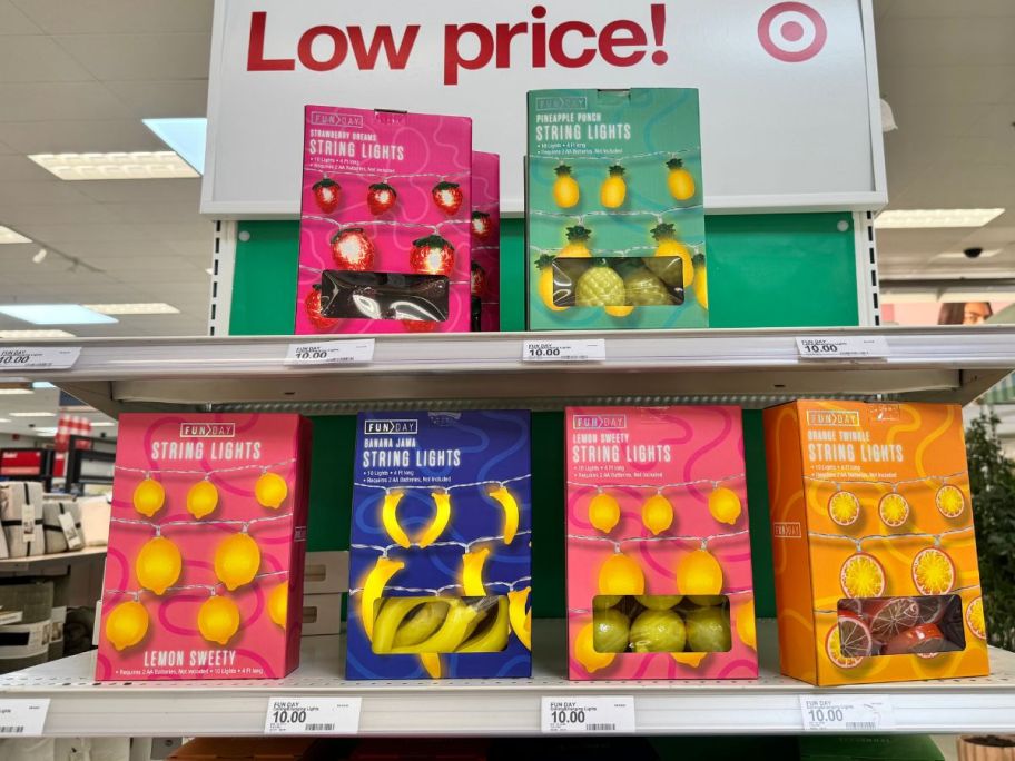 Several fruit-shaped string light sets in boxes on an end cap at target