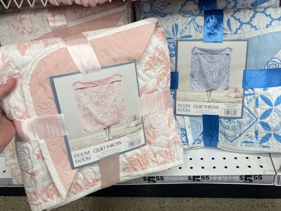 A person holding a comforter for a bed