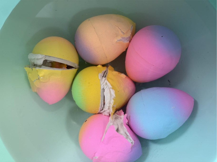 rainbow eggs in a bowl of water breaking open to reveal Unicorns toys inside