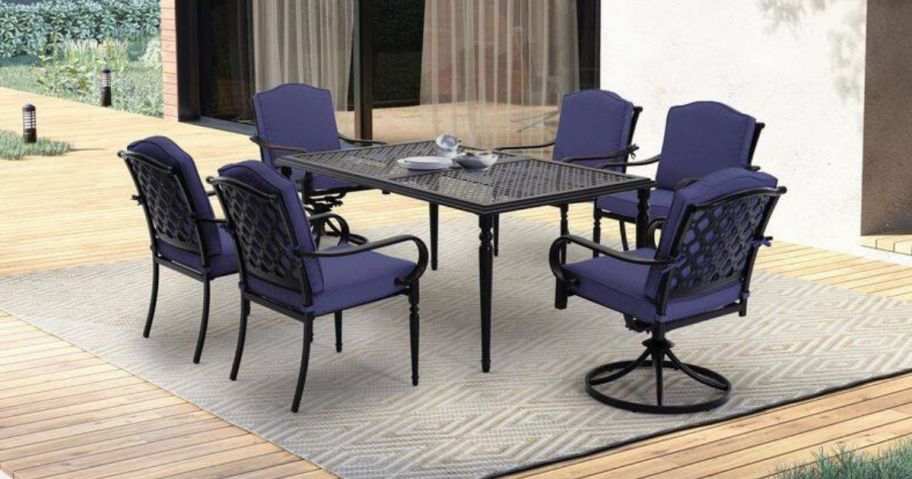 A patio dining room set with navy cushions