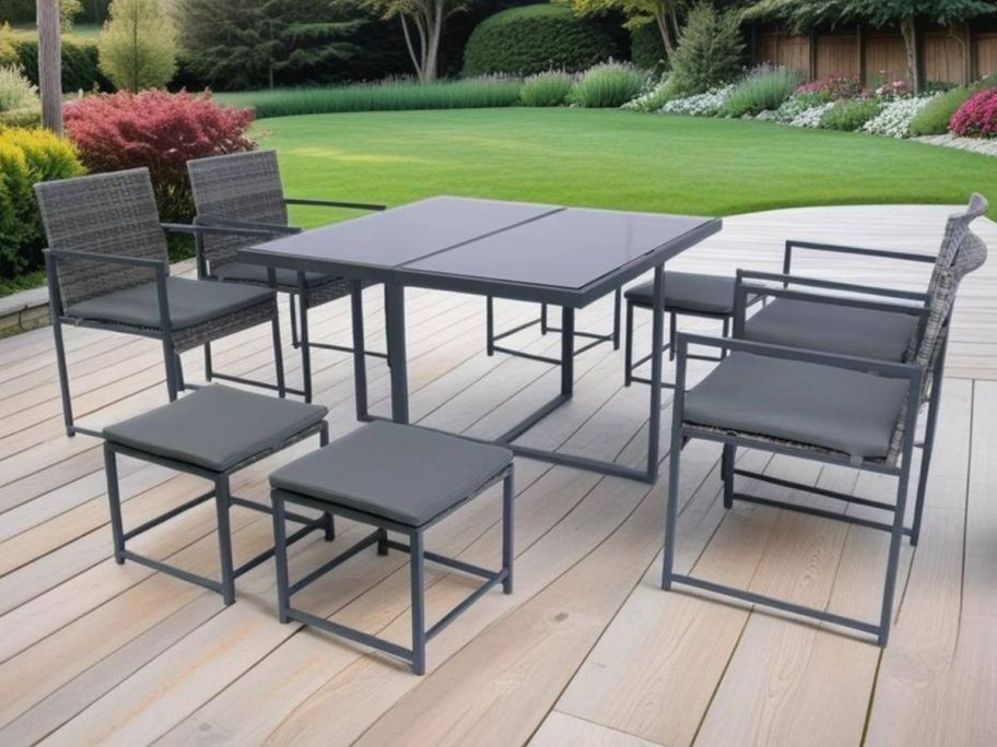 An outdoor table with a glass top and chairs with cushions