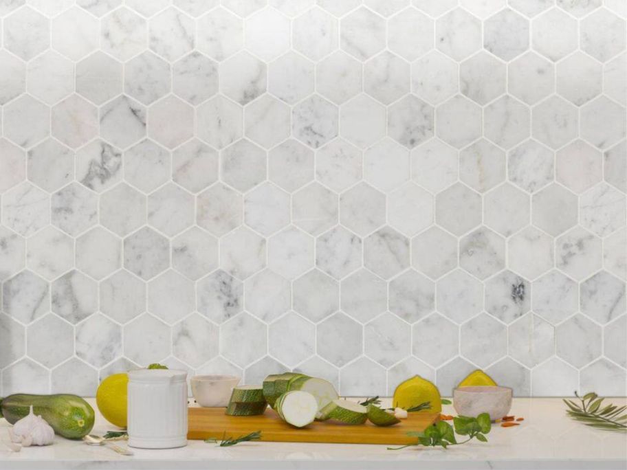 A kitchen wall with MSI Carrara White 2" Hexagon Honed Marble 12x12 Mosaic Tile