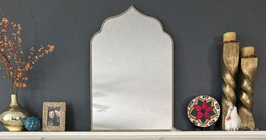 A mantel with a home depot mirror on it