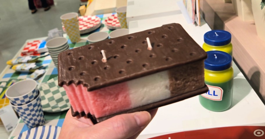 Woman holding up ice cream sandwich candle with two wicks inside target store