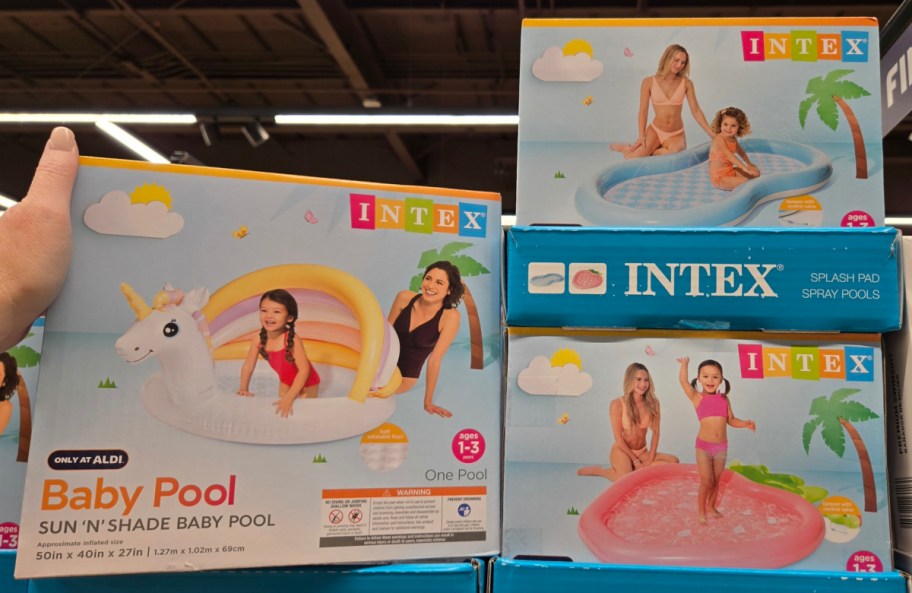 Hand holding Intex pools in different forms for kids displayed ay the ALDI's store