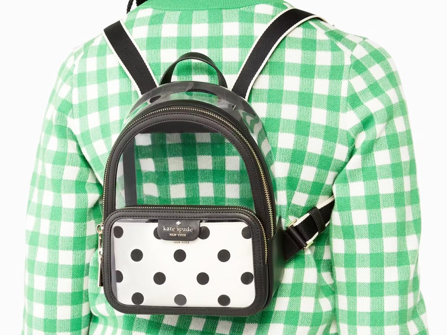 woman in a white and green plaid sweater with a clear mini backpack