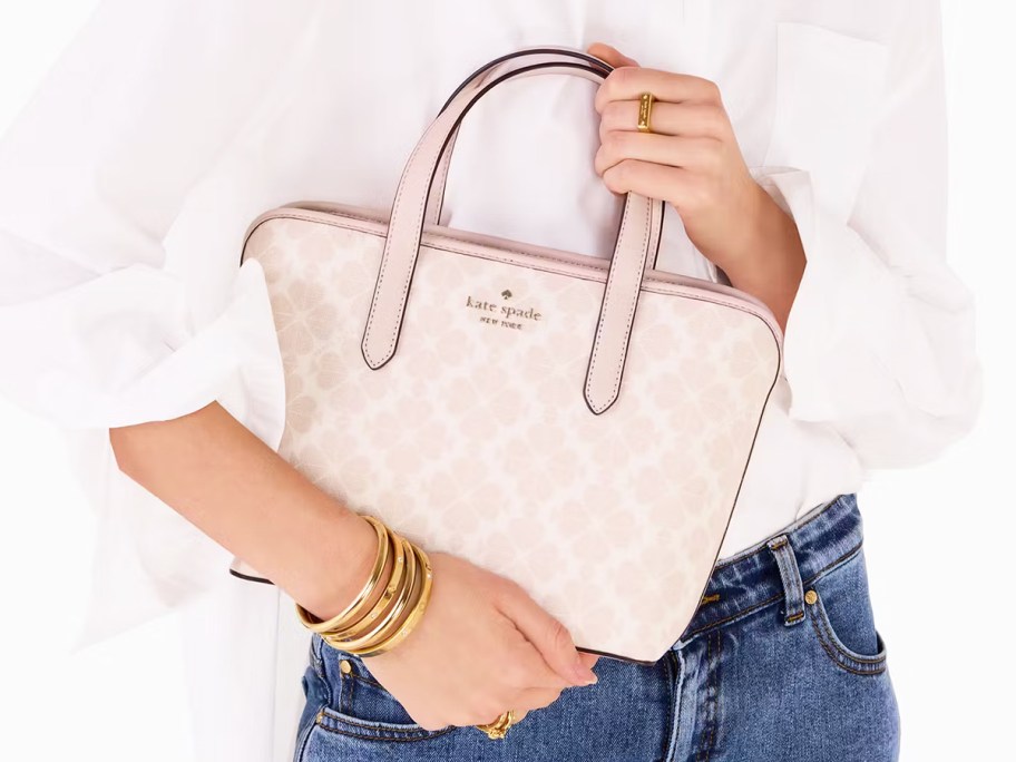 woman holding a light pink floral print tote bag