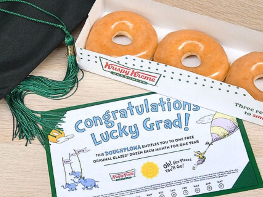 A Krispy Kreme Doughploma next to a glazed dozen 3-pack and a graduation cap