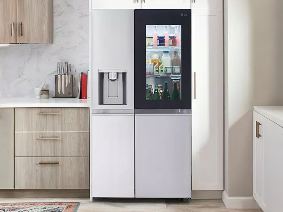 LG 27 cu. ft. Side-By-Side Refrigerator with InstaView in a kitchen with cabinets