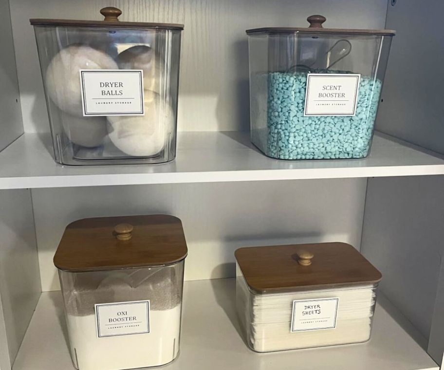 4 canisters in a cupboard with laundry detergent items in them 
