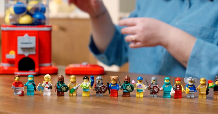 Red Lego vending machine with 16 mini figures on wooden table top