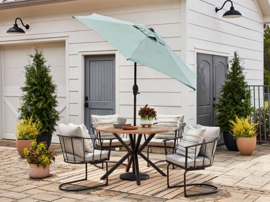 A Style Selections 7.5' Steel Push-button Tilt Market Patio Umbrella on an outdoor patio set