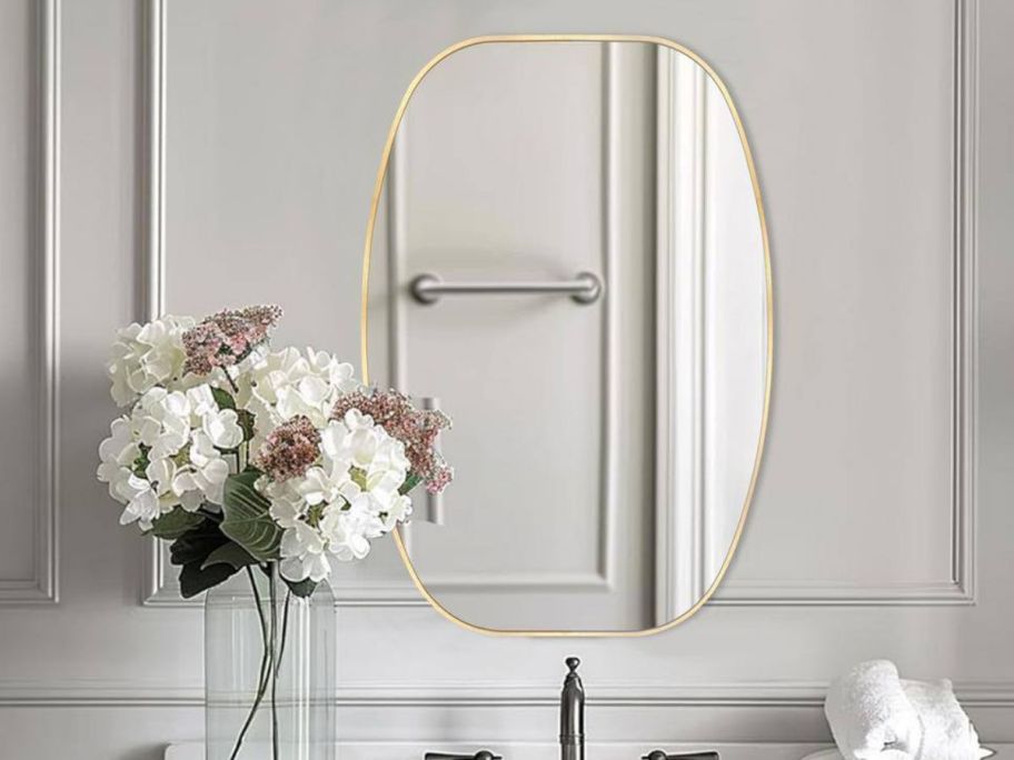 A golden oval mirror in a bathroom