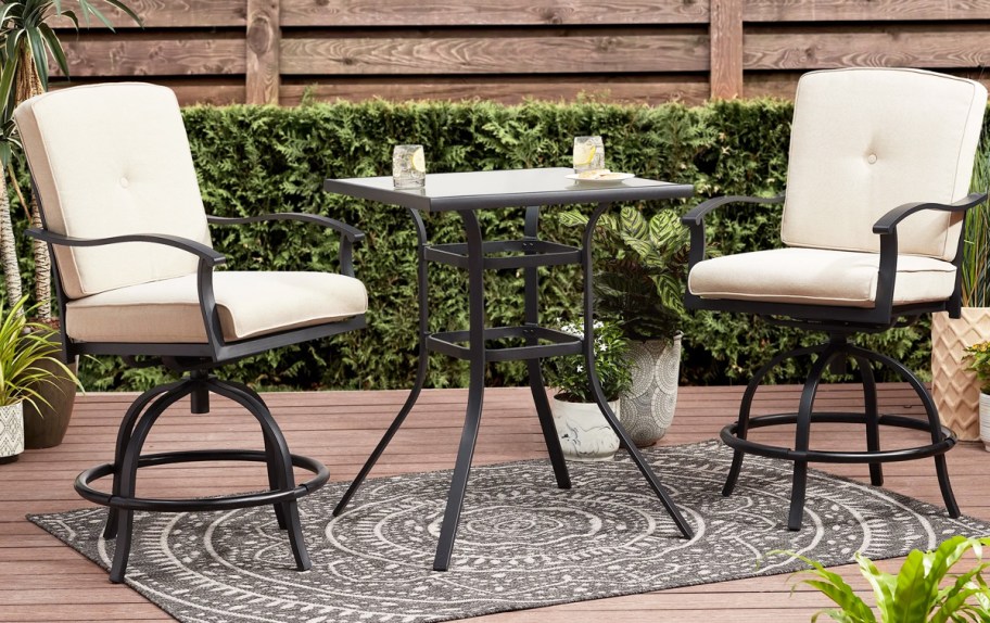 two patio chairs with white cushions and matching table
