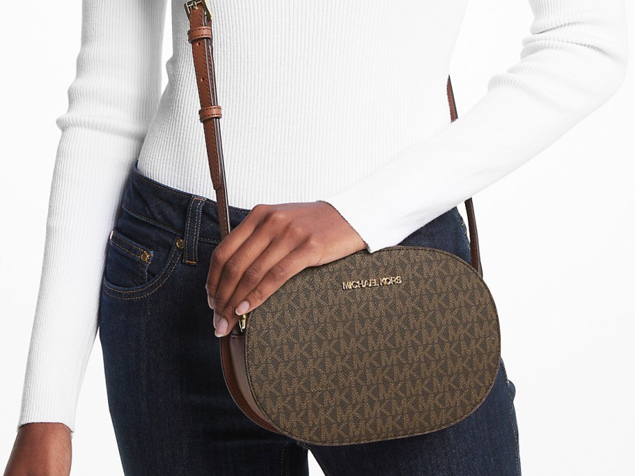woman in a white top and jeans with brown crossbody bag
