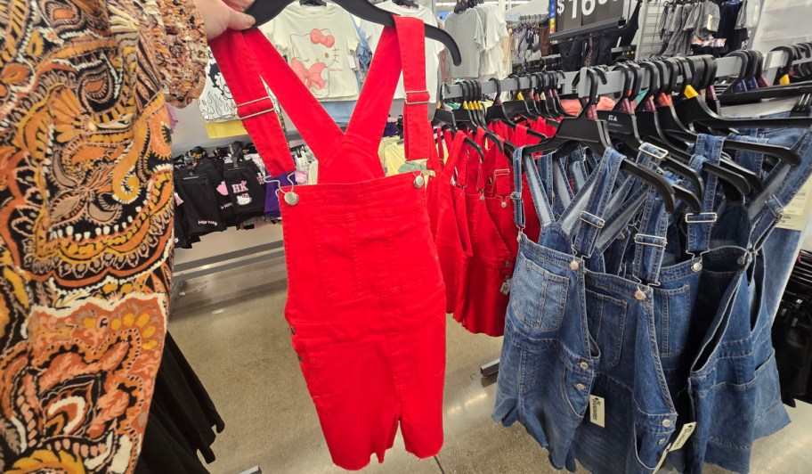 red denim No Boundaries Denim Shortalls on a hanger