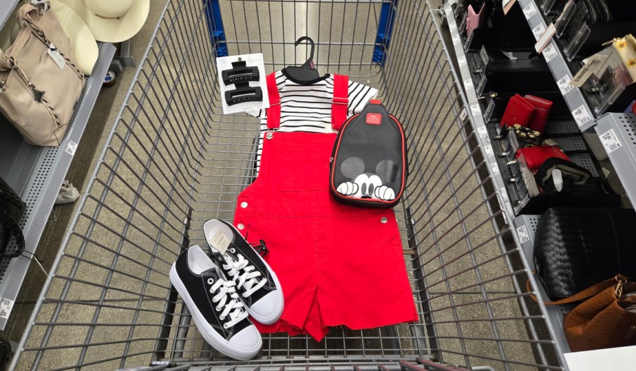 red women's shortalls, striped shirt, hair clips and black and white sneakers in a shopping cart.