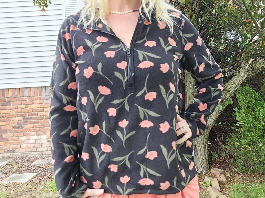 woman wearing a black and pink flower print half-zip hoodie