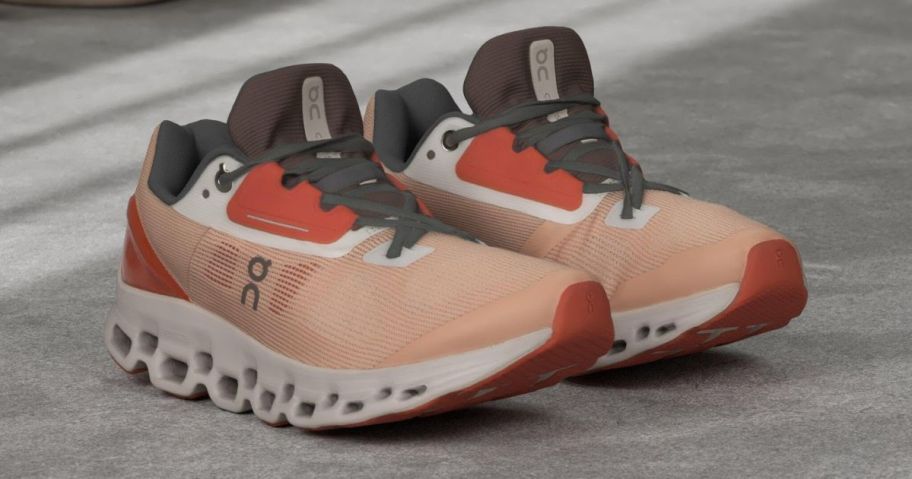 A pair of On Running Cloudstratus 2 Women's Shoes in the Rose/Red color option in the middle of a floor