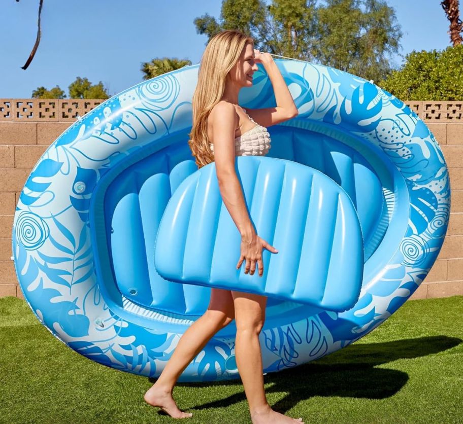 a woman carrying an inflatable tanning pool