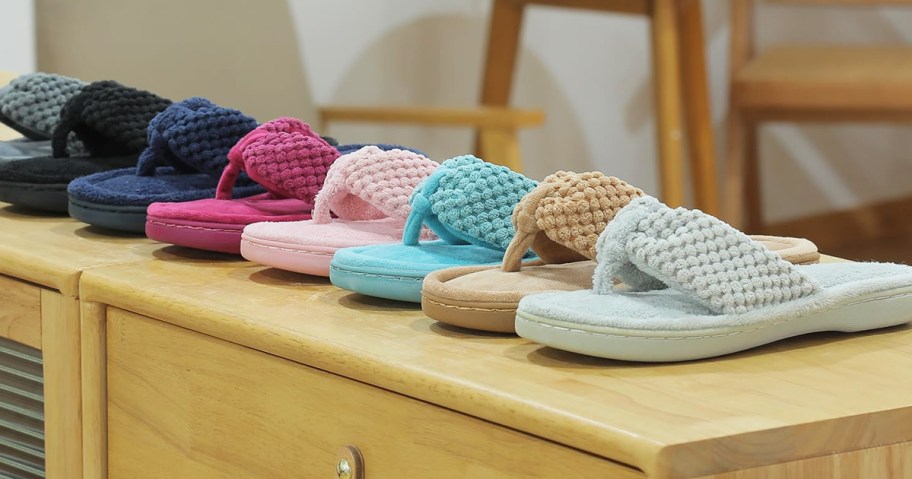 row of flip flop slippers in various colors on a wood console table