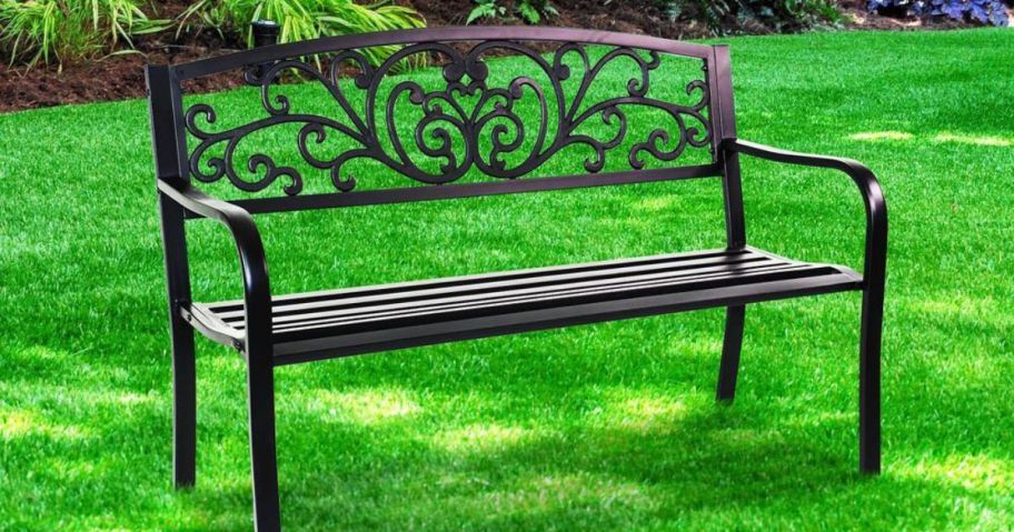 A metal patio bench on the grass