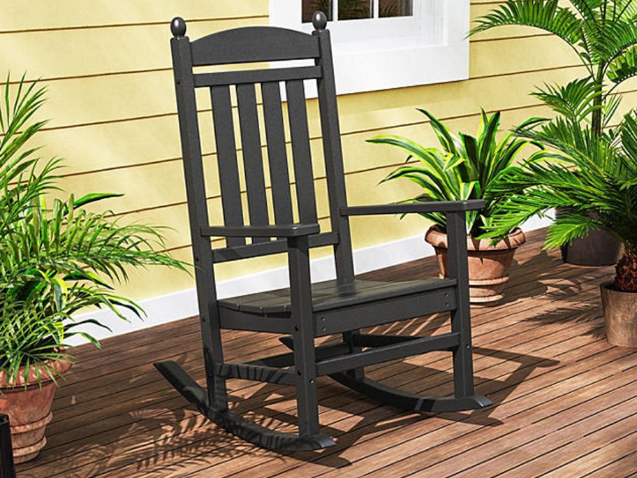 Polywood Gulf Shores Rocking Chair on a wooden porch outside of a house