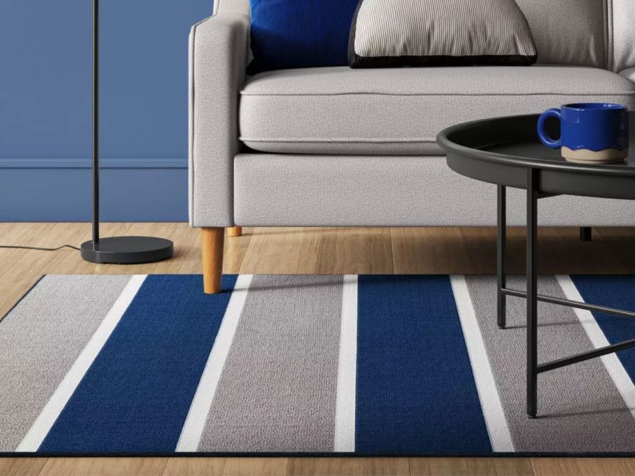 A blue, white, and gray rugby accent rug in a living room