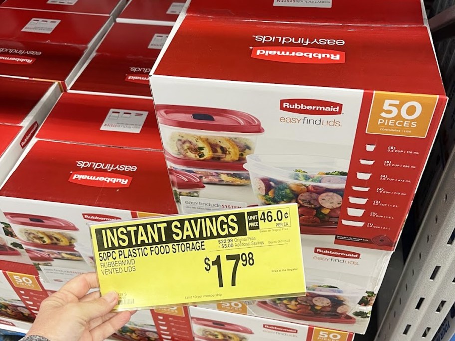 hand holding yellow sale tag in front of box of food storage containers