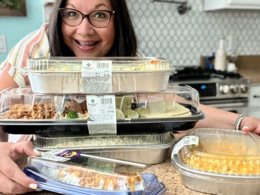 Woman with a stack of Member's Mark pre-made meals on her counter