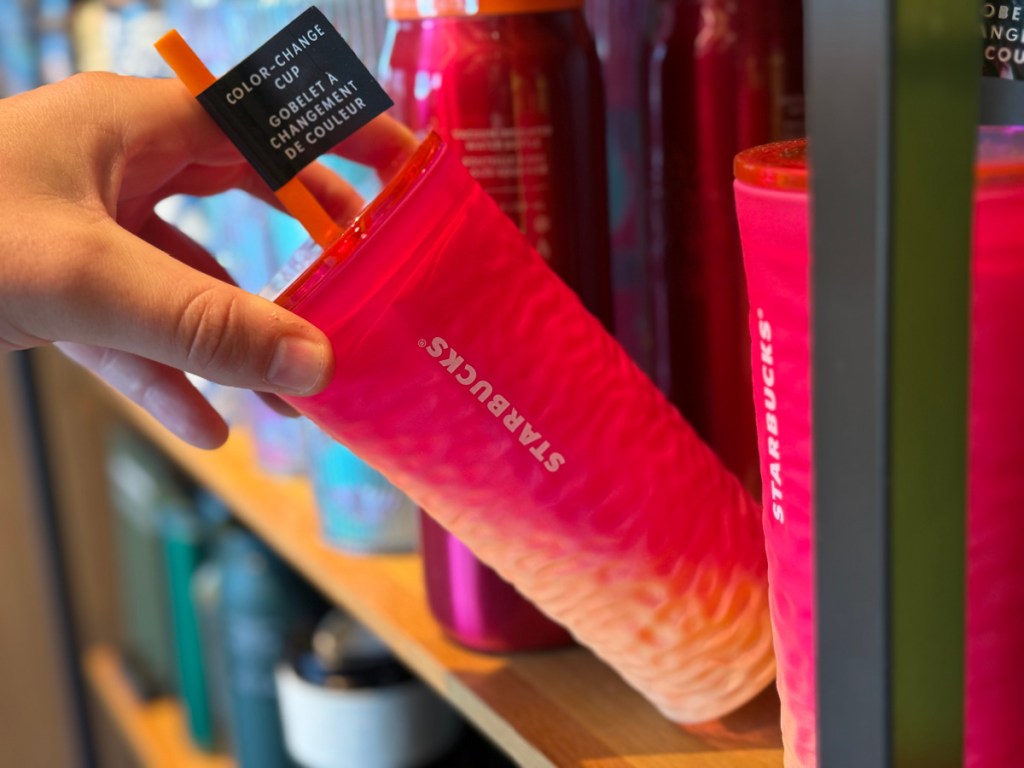 Person grabbing Starbucks color change cup off of shelf