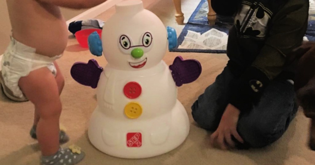 Two small children playing with step to my first snowman in living room