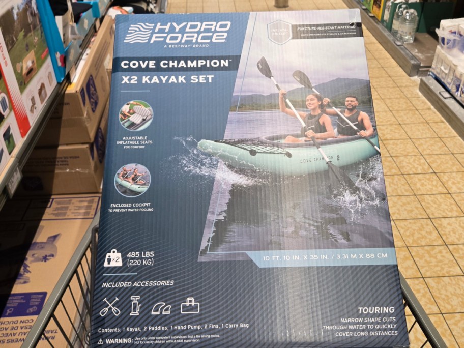 inflatable kayak set sitting in its box inside of an ALDIs shopping cart