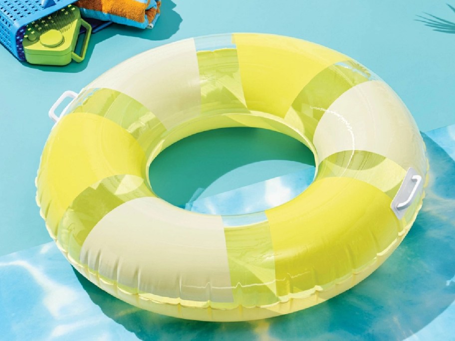 Tube pool float in yelllow displayed at the pool 