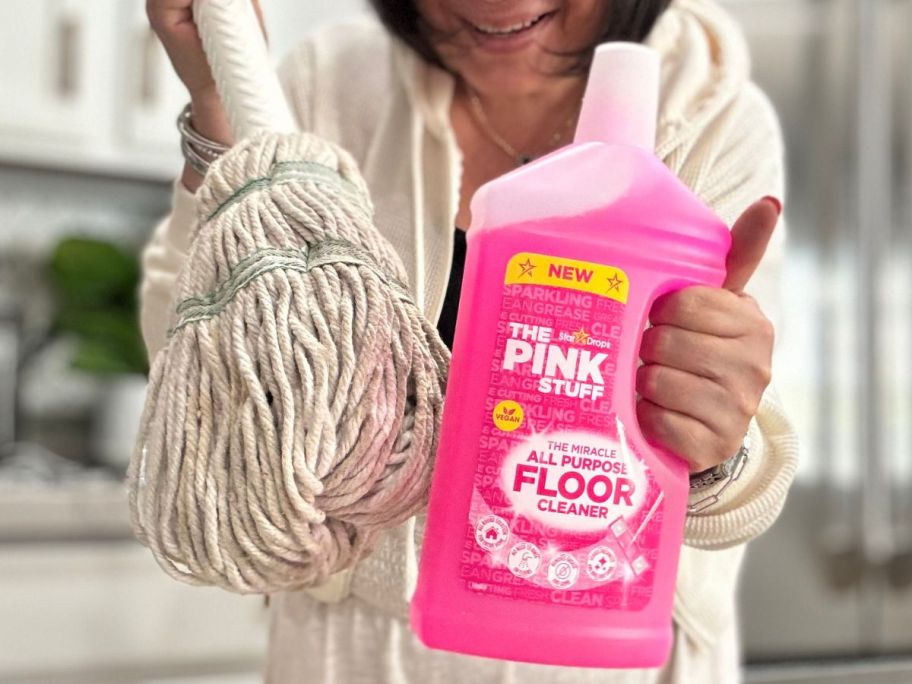 Woman holdig a mop and The Pink Stuff floor cleaner
