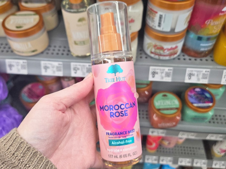 hand holding a pink bottle of Tree Hut Fragrance Mist in Moroccan Rose scent in store
