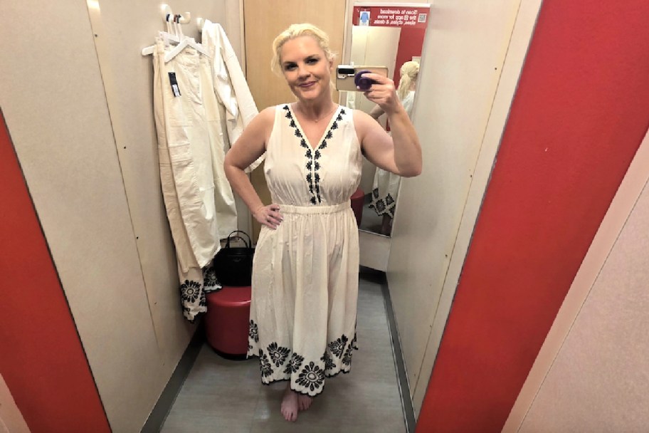 woman posing in a black and white dress in a fitting room