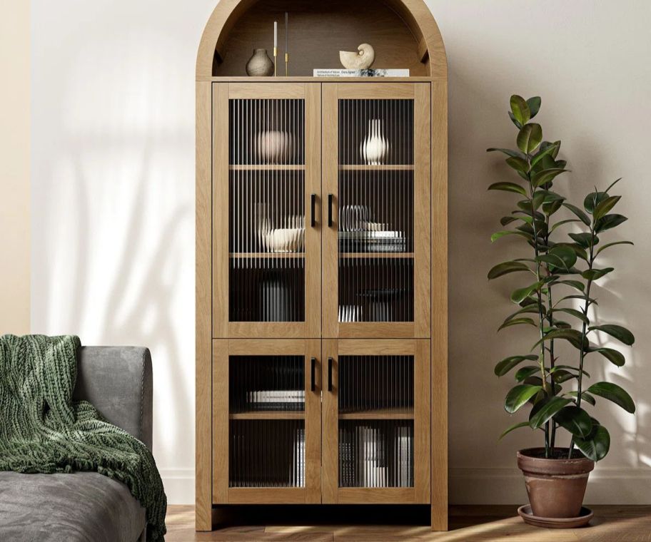 A brown arched display cabinet 